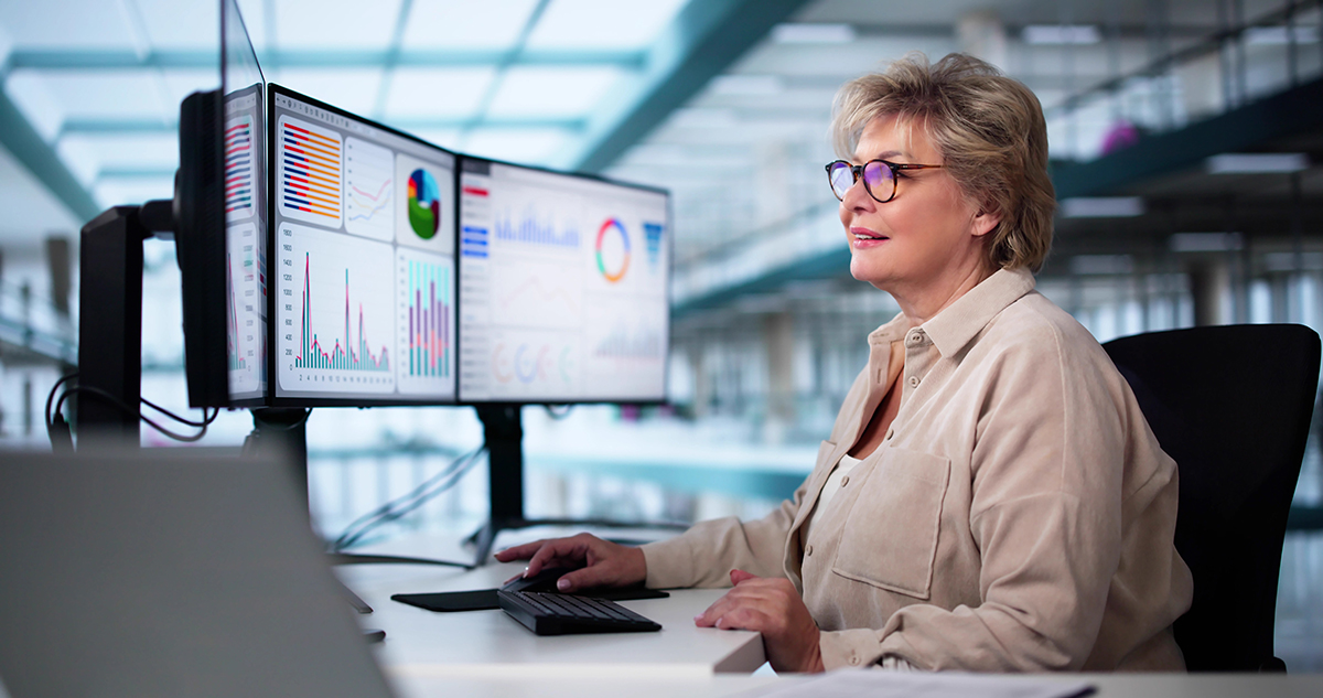 Business Data Analytics Dashboard A public sector employee reviewing digital dashboards displaying key performance indicators, symbolizing transparency and service performance optimization through C2 ITSM.