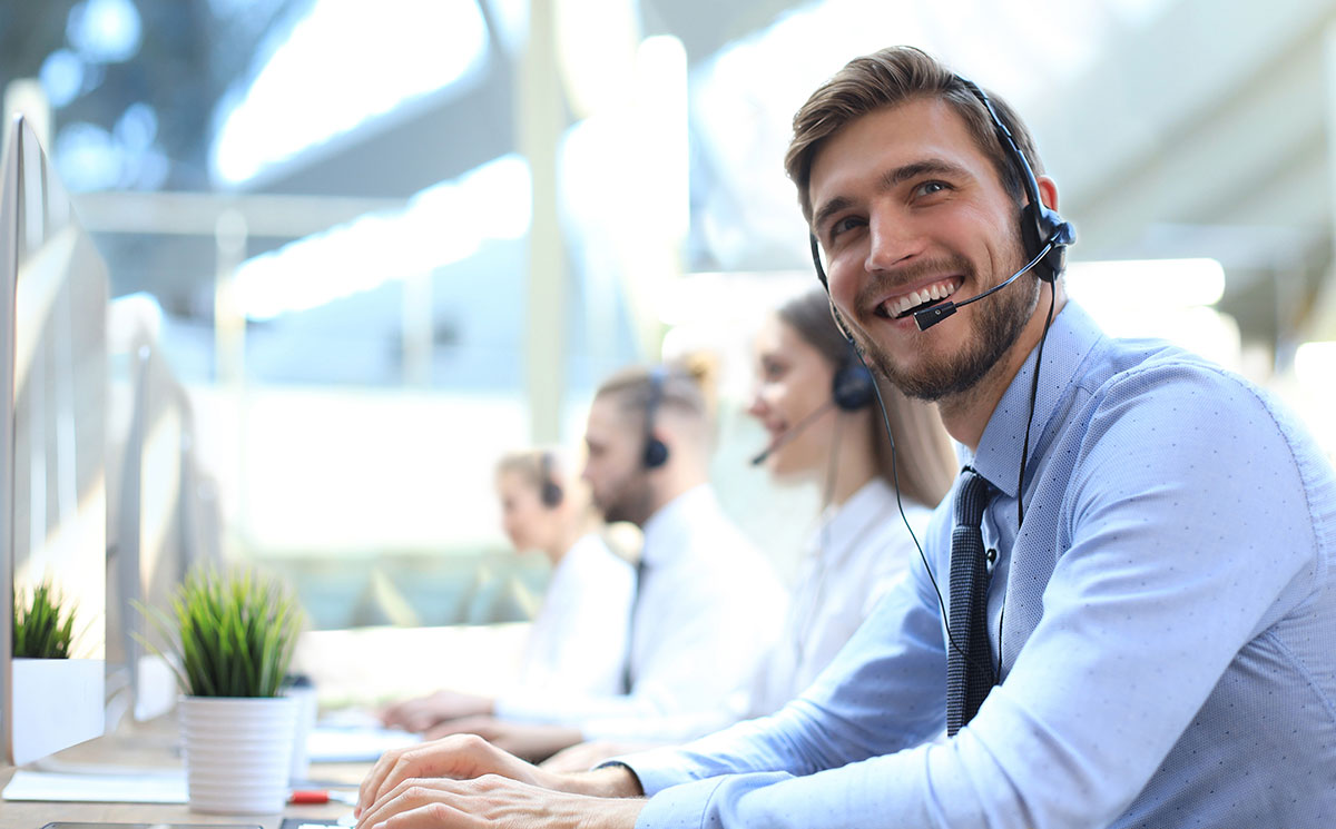 AdobeStock_332086439 IT support agents wearing headsets in a bright office – centralized ticket management with C2 ITSM.
