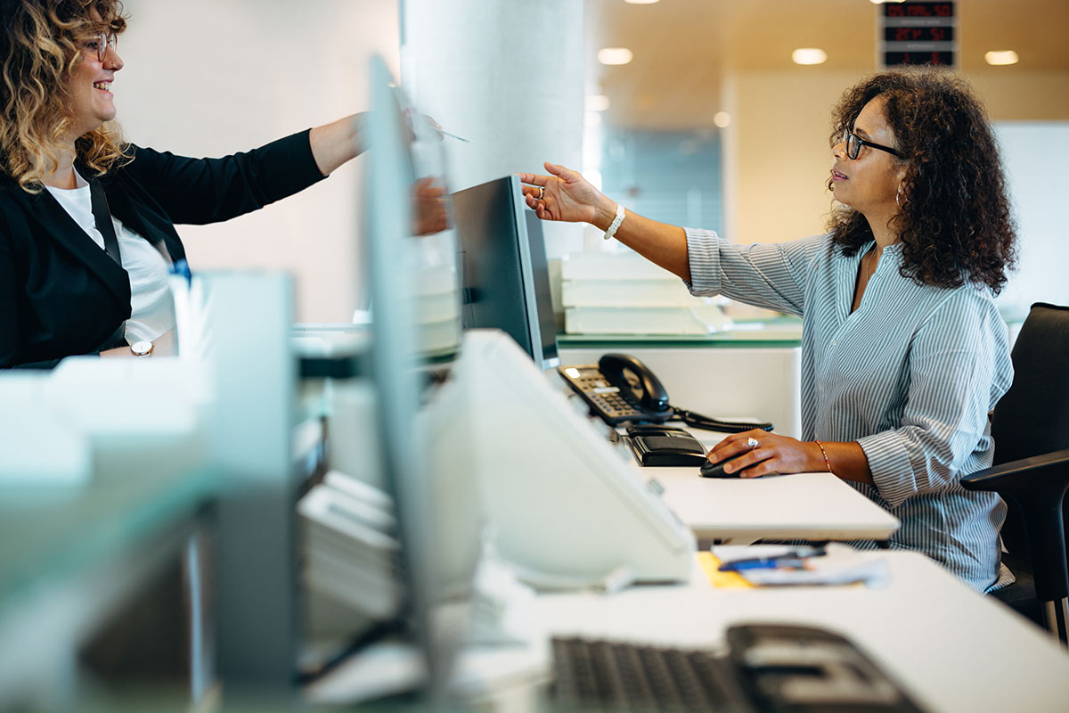 AdobeStock_416474234 Municipal employee assisting a resident at a service counter, symbolizing efficient citizen request management through C2 ITSM.