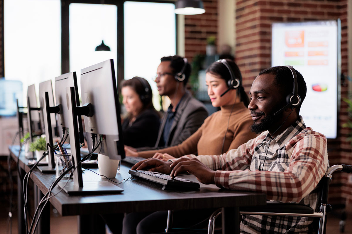 AdobeStock_505081529 IT support team at desks with multiple monitors, proactively managing problems and monitoring systems.