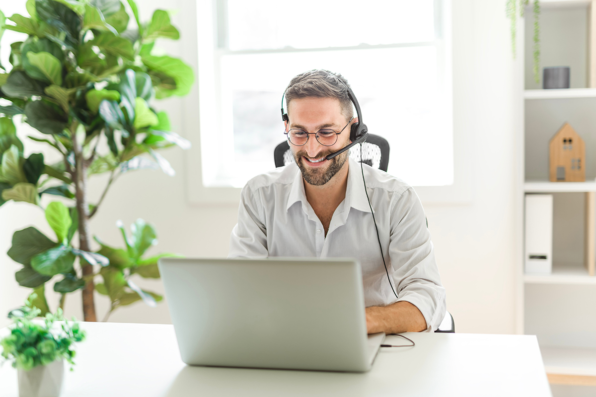 Mature analyst man using laptop computer in office. Employee monitoring SLA compliance and urgent requests with C2 ITSM dashboard indicators.
