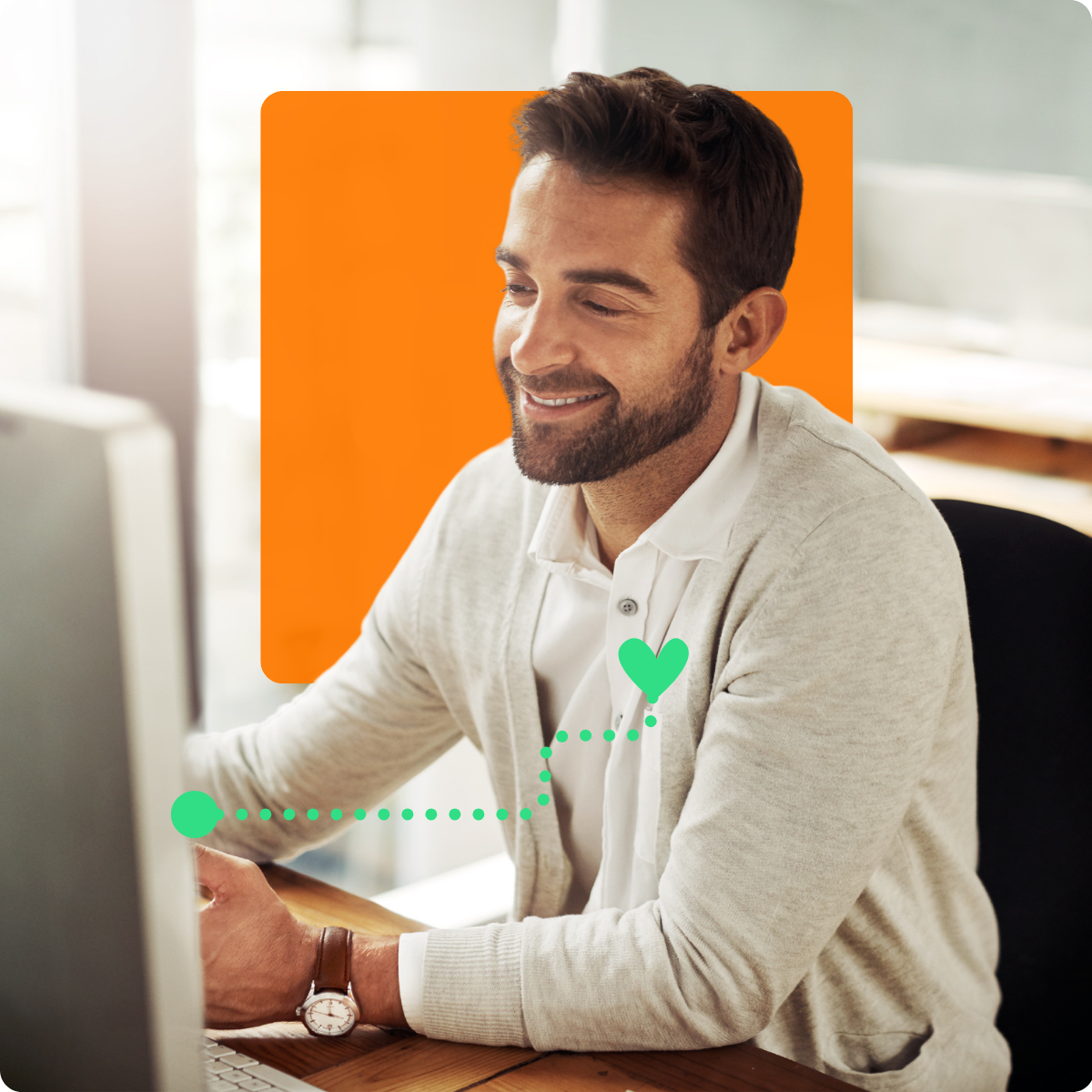 Professionnel TI souriant au bureau devant son ordinateur – utilisateur satisfait de la solution C2 ITSM pour la gestion des services