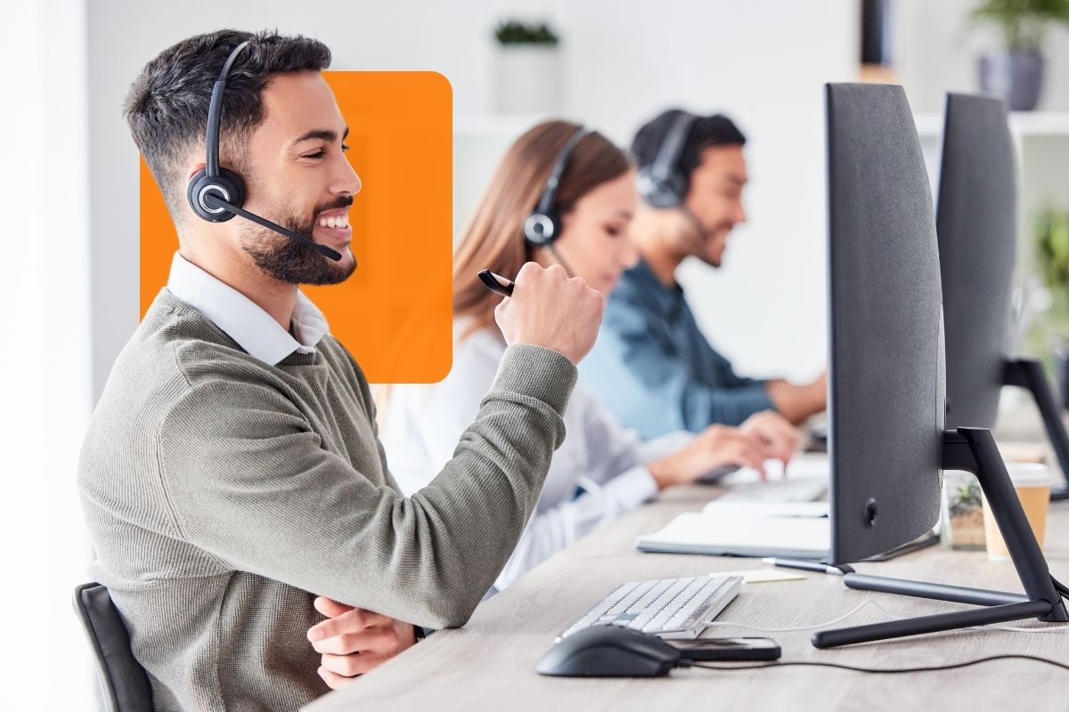 Professionnel TI souriant au bureau devant son ordinateur – utilisateur satisfait de la solution C2 ITSM pour la gestion des services